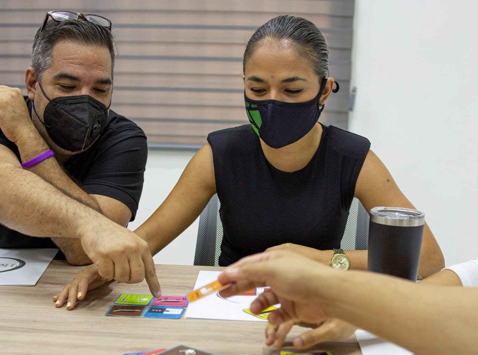 Colaboradores de Grupo Libera Inmobiliaria señalando tarjetas Habraz sobre la mesa