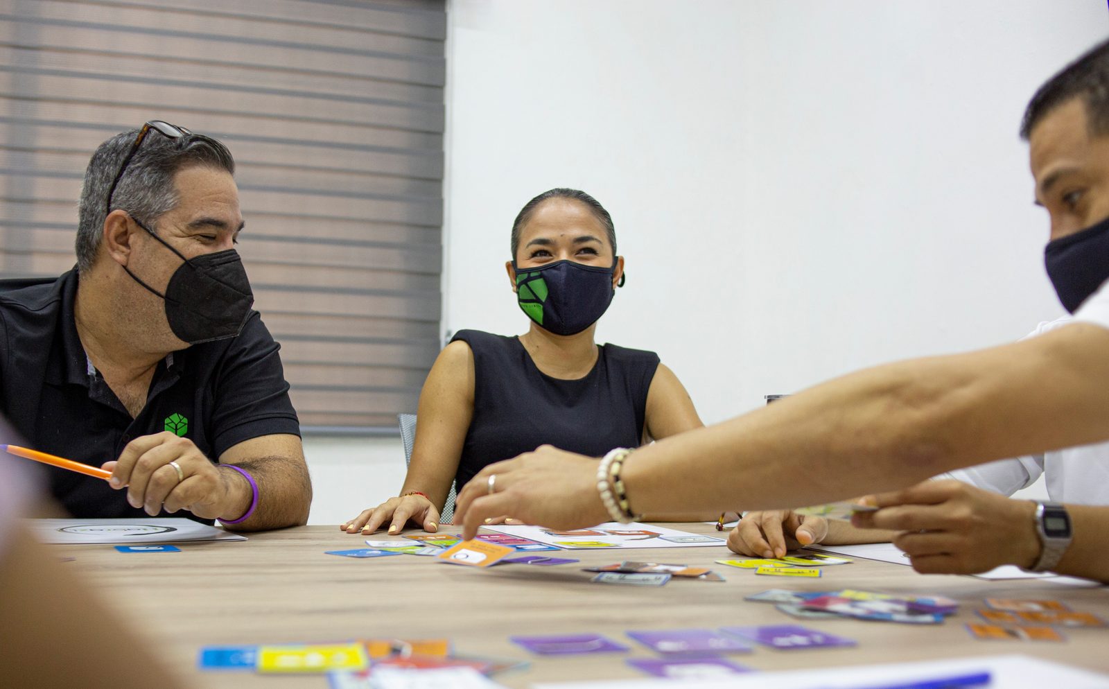 Colaboradores de Grupo Libera Inmobiliaria conversando durante dinámica con tarjetas Habraz
