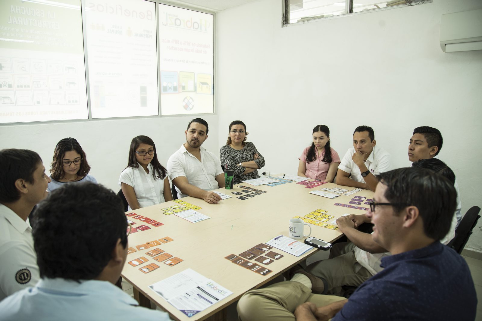 Equipo de Lavalle y Asociados sentado alrededor de la mesa con tarjetas Habraz durante sesión de entrenamiento