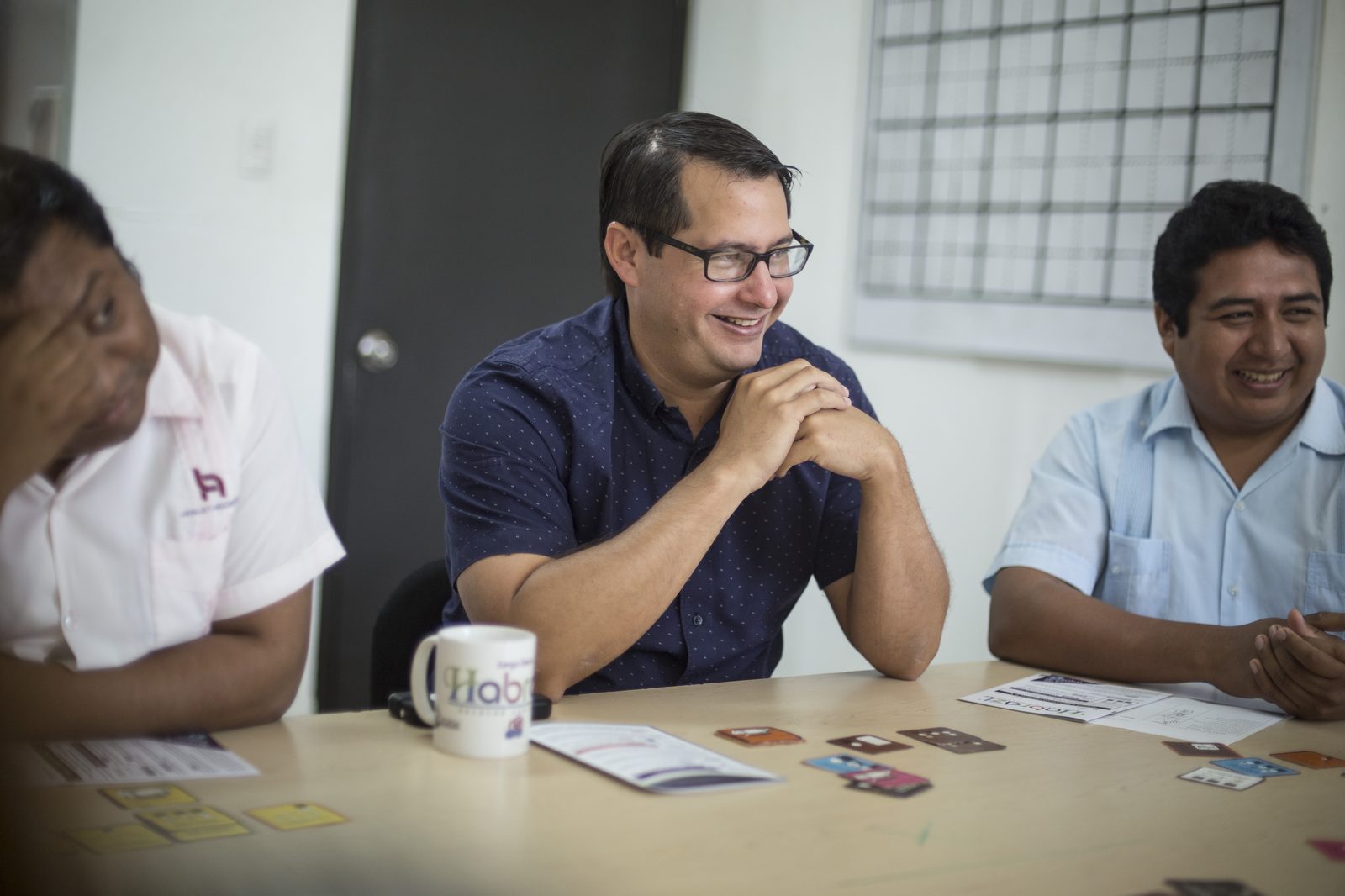 Colaborador de Lavalle y Asociados sonriendo junto a taza personalizada Habraz sobre la mesa