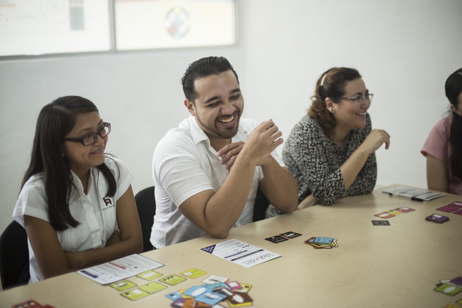 Colaboradores de Lavalle y Asociados riendo durante dinámica grupal con tarjetas Habraz