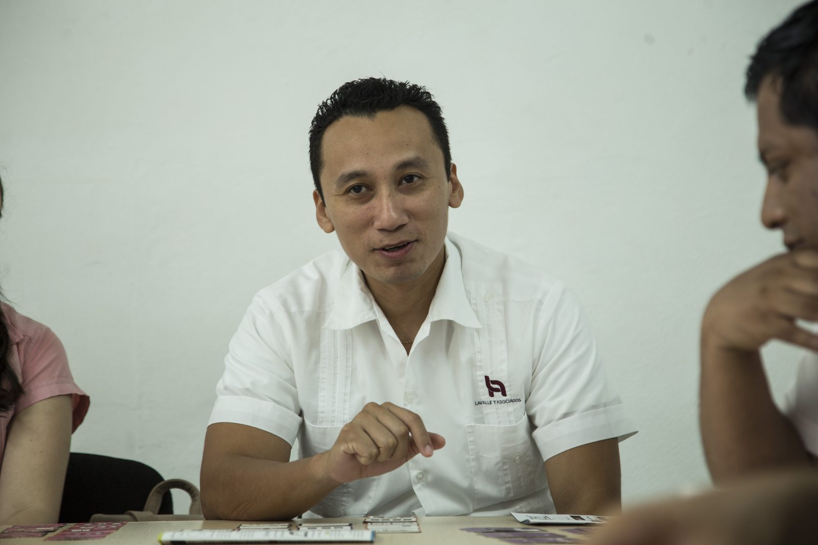 Colaborador de Lavalle y Asociados con playera bordada del despacho explicando un punto durante la sesión